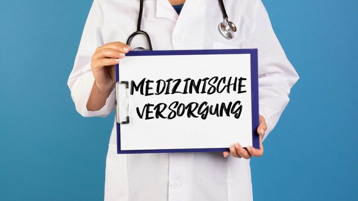 Doctor Holding Clipboard With Medizinische Versorgung Text